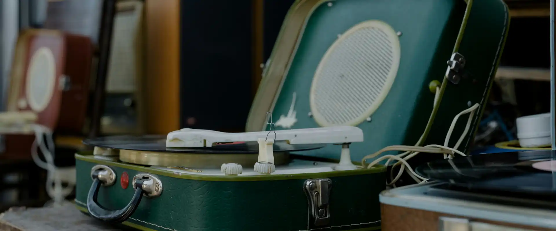 Close-up van een groene vintage draagbare platenspeler met vinylplaat als nostalgisch muziekapparaat